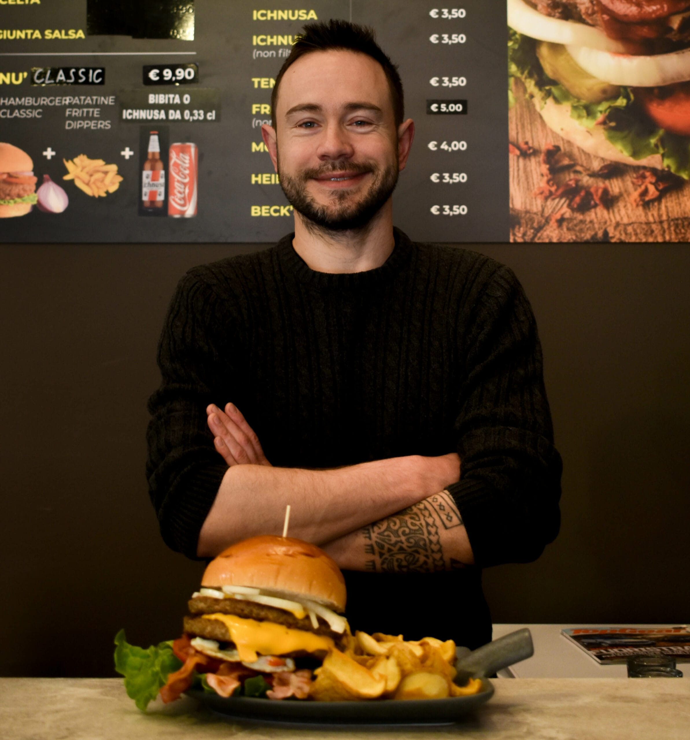 Ivan Crilov sorridente dopo aver preparato un hamburger delizioso