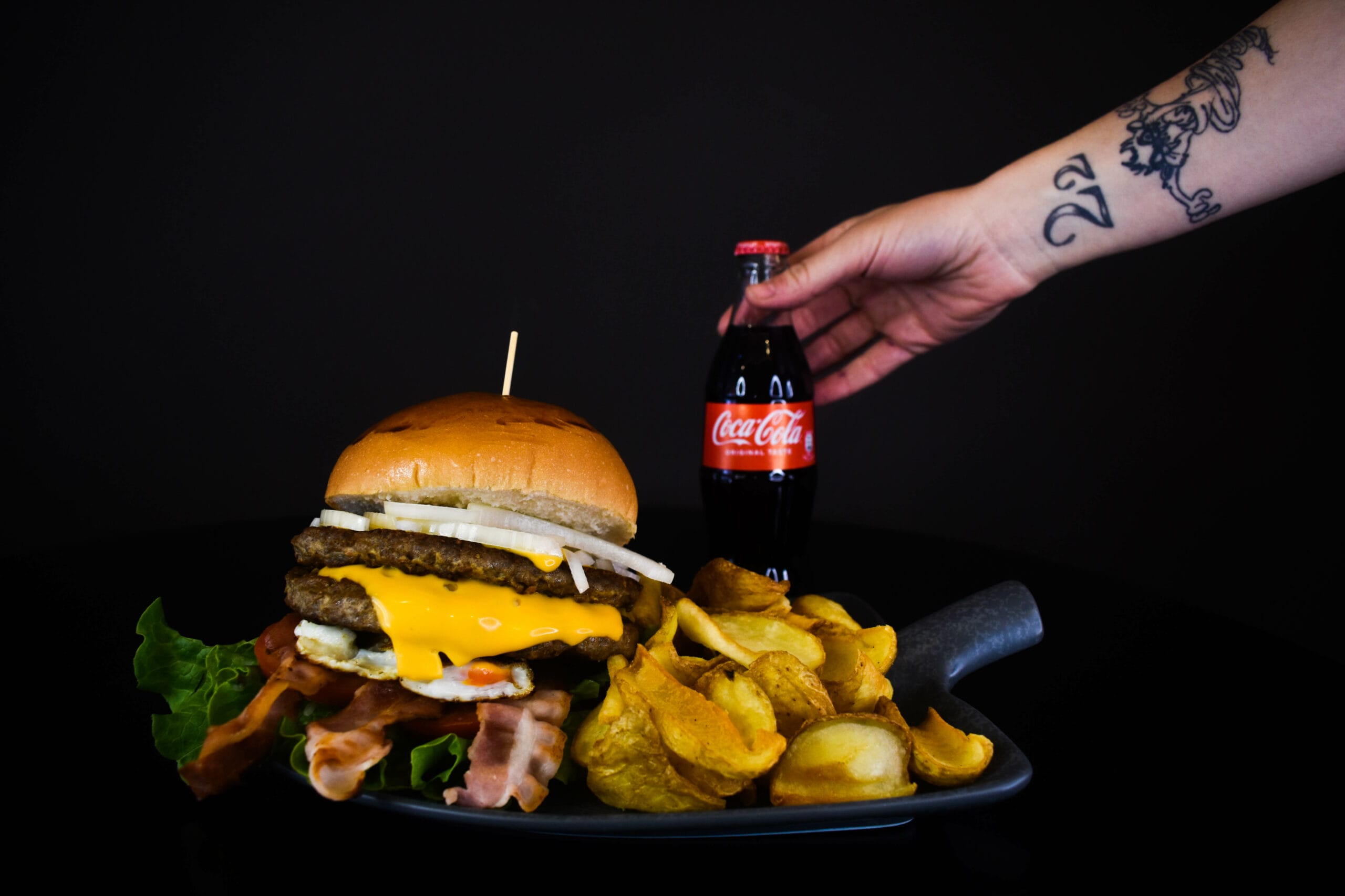 Delizioso hamburger con bacon di Hamburgeria Mordi accompagnato da una Coca Cola